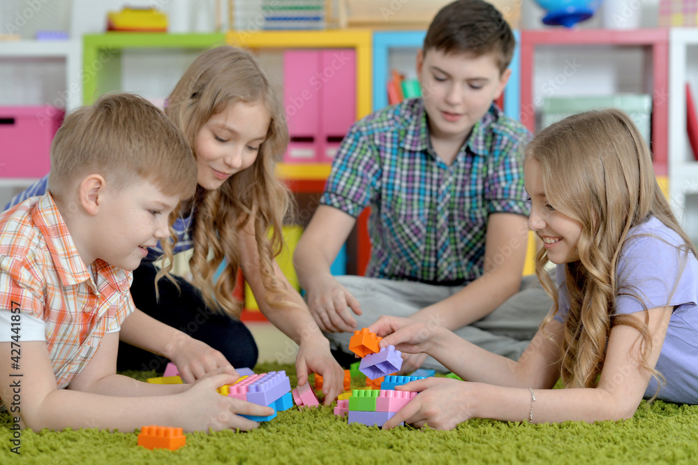 Fototapeta premium Children playing together floor with green carpet