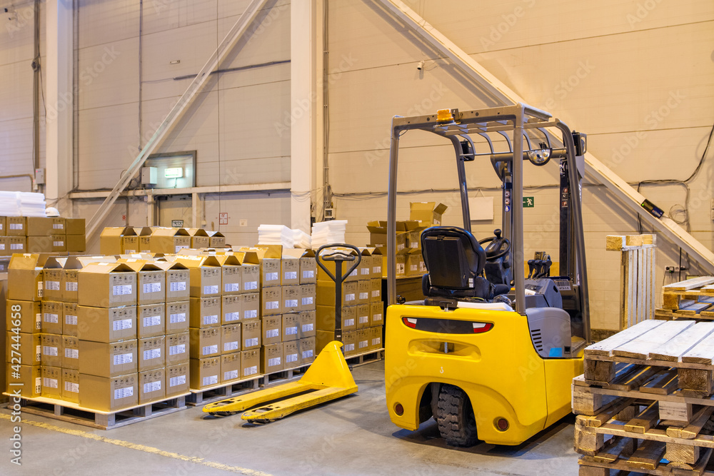 Forklift loader parking at logistics warehouse. Pallet stacker truck equipment inside of a modern warehouse storage Forklift loader parking at logistics warehouse. Pallet stacker truck equipment inside of a modern warehouse storage