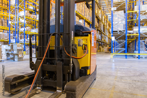 Electrical forklift loader charging in the warehouse. Pallet stacker truck equipment inside of a modern warehouse storage photo