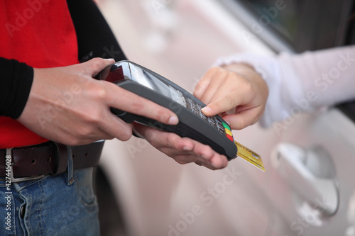 woman refill oil pay credit card , woman in car paying credit card after refuel car spending instead of cash with service employee at gas station. petrol business finance energy concept.