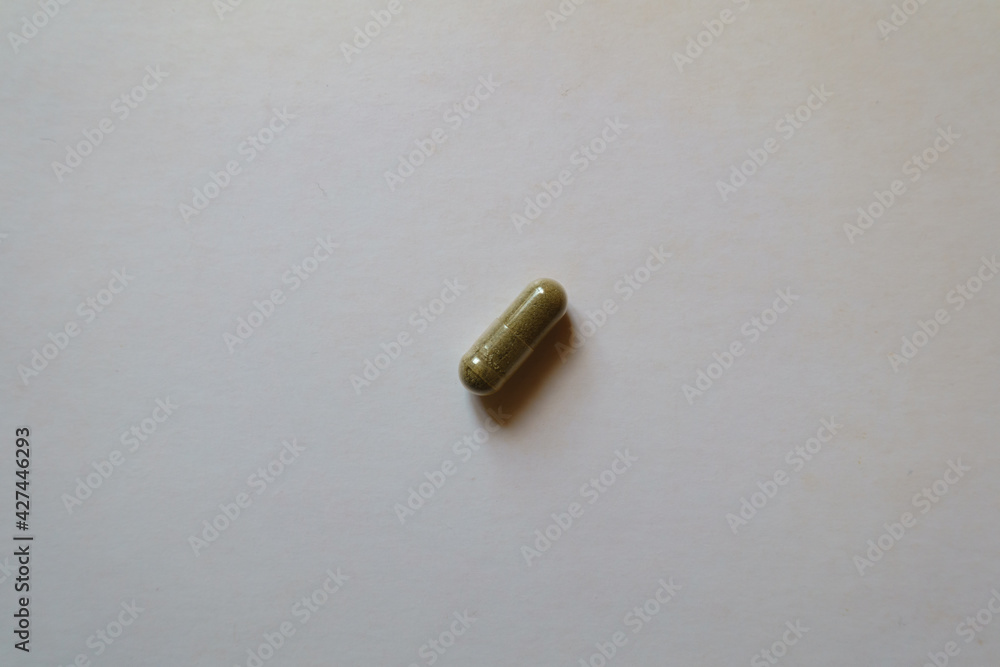 Naklejka premium 1 greenish brown capsule of iron bisglycinate from above
