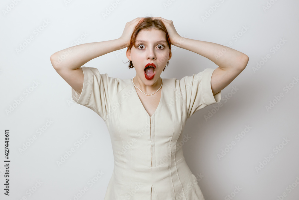 Portrait of a surprised girl with red lips on a light background Portrait of a surprised girl with red lips on a light background