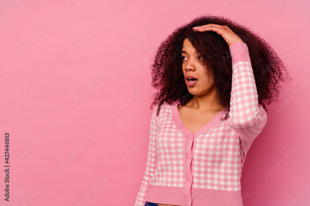 Young african american woman isolated on pink background looking far away keeping hand on forehead. Young african american woman isolated on pink background looking far away keeping hand on forehead.
