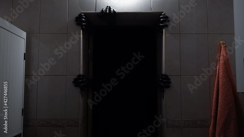 A demon from the darkness grabs the doorway with its hands. Deno from hell.