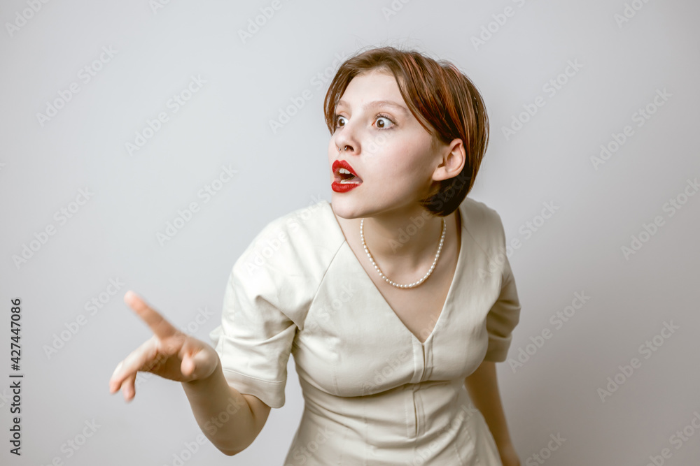 Portrait of a surprised girl with red lips on a light background Portrait of a surprised girl with red lips on a light background
