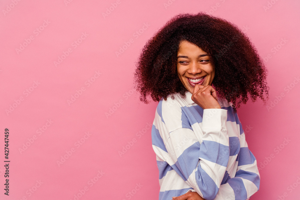 Young african american woman isolated on pink background relaxed thinking about something looking at a copy space. Young african american woman isolated on pink background relaxed thinking about something looking at a copy space.