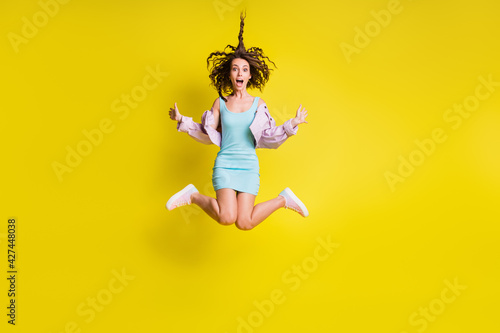Full body photo of excited pretty person jump high open mouth hair flying isolated on yellow color background