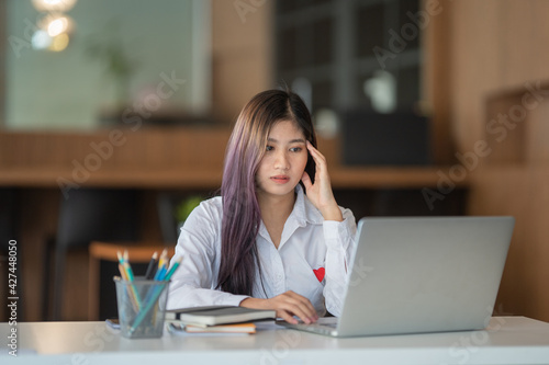 Asian businesswoman gets stressed while having a problem at work in the office.