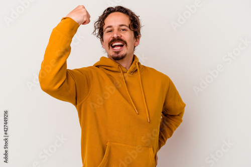 Young caucasian man isolated on white background cheering carefree and excited. Victory concept.