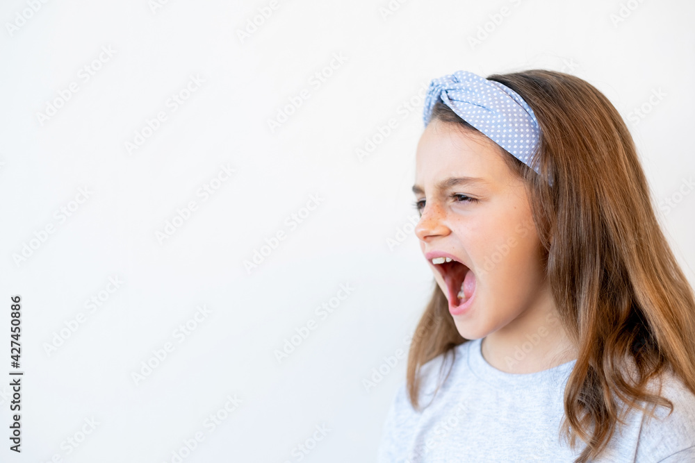 Naughty kid portrait. Temper tantrum. Child behavior problem. Troubled unhappy noisy little girl yelling with open mouth raising voice isolated on white empty space background. Naughty kid portrait. Temper tantrum. Child behavior problem. Troubled unhappy noisy little girl yelling with open mouth raising voice isolated on white empty space background.