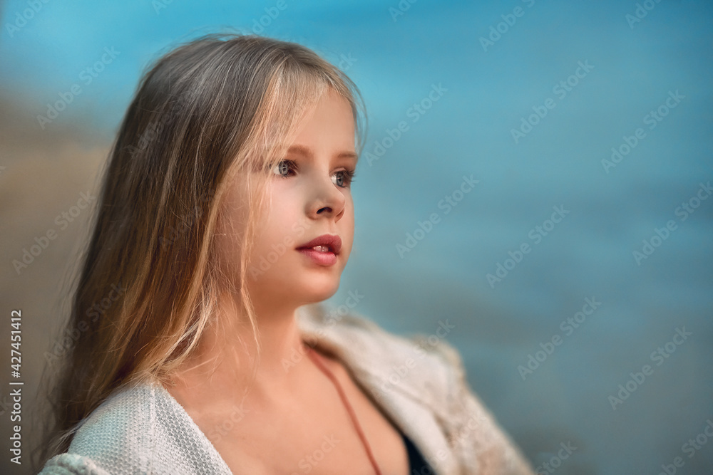 a girl sits on the seashore and looks at the sunset a girl sits on the seashore and looks at the sunset