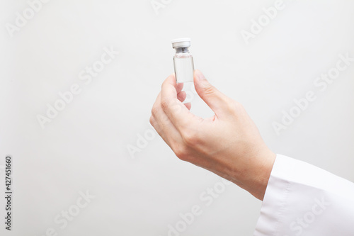 医療関係者の手に持たれたワクチンのガラス瓶