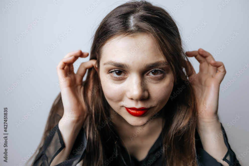 Beautiful woman straightens her long hair, close-up portrait Beautiful woman straightens her long hair, close-up portrait