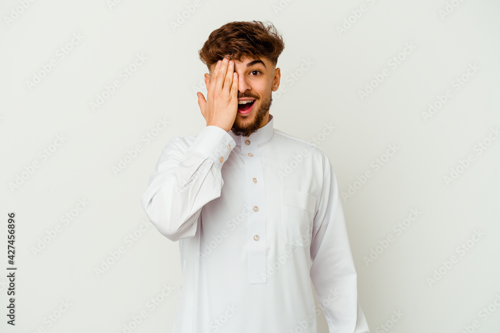 Young Moroccan man wearing a typical arab clothes isolated on white background having fun covering half of face with palm. Young Moroccan man wearing a typical arab clothes isolated on white background having fun covering half of face with palm.