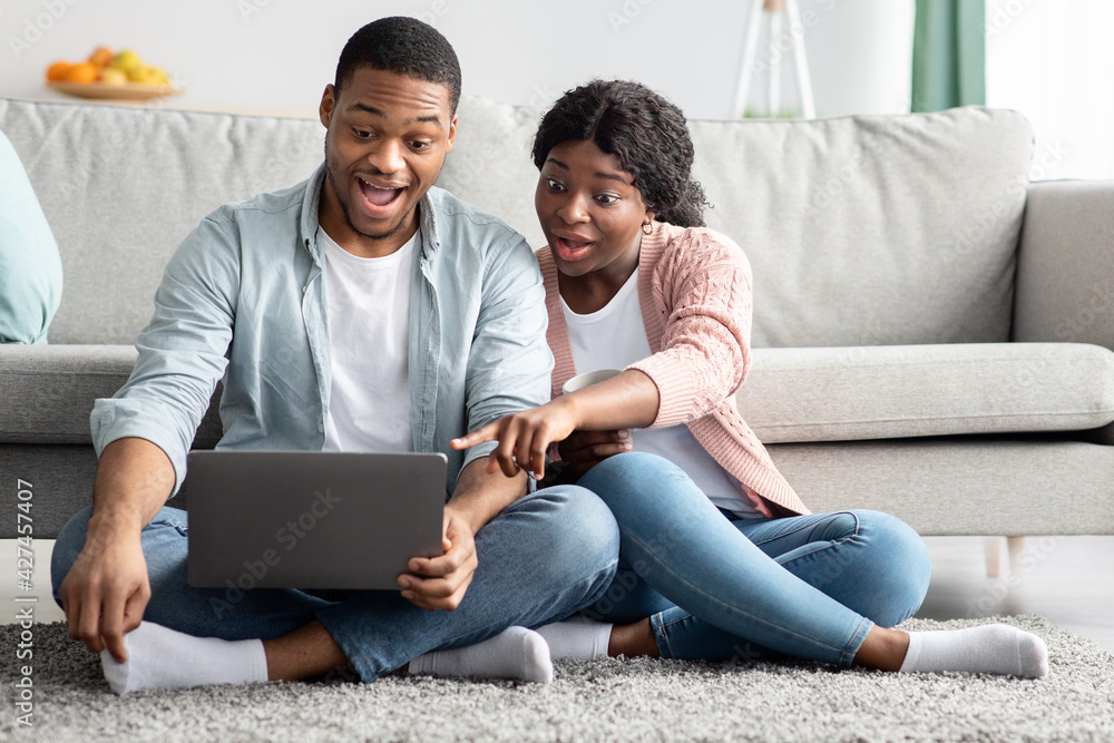 Amazed african american couple using laptop at home Amazed african american couple using laptop at home