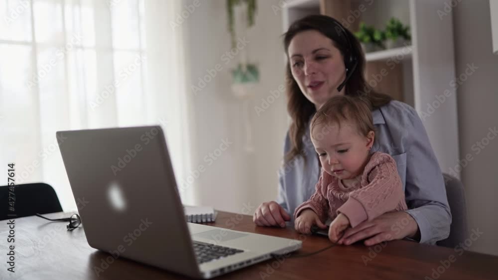 A sad and frustrated mother in kitchen home office with computer and her daughter A sad and frustrated mother in kitchen home office with computer and her daughter