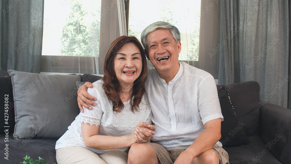 Asian elderly couple watching television in living room at home, sweet couple enjoy love moment while lying on the sofa when relaxed at home. Enjoying time lifestyle senior family at home concept. Asian elderly couple watching television in living room at home, sweet couple enjoy love moment while lying on the sofa when relaxed at home. Enjoying time lifestyle senior family at home concept.