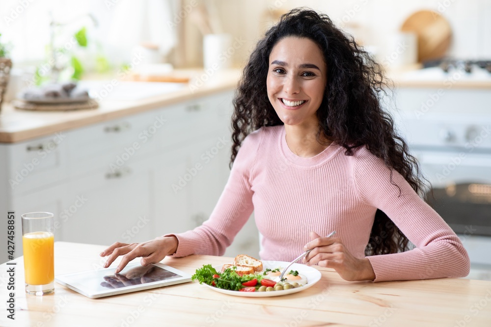 Portraif Of Happy Smiling Young Lady Having Breakfast And Using Digital Tablet Portraif Of Happy Smiling Young Lady Having Breakfast And Using Digital Tablet