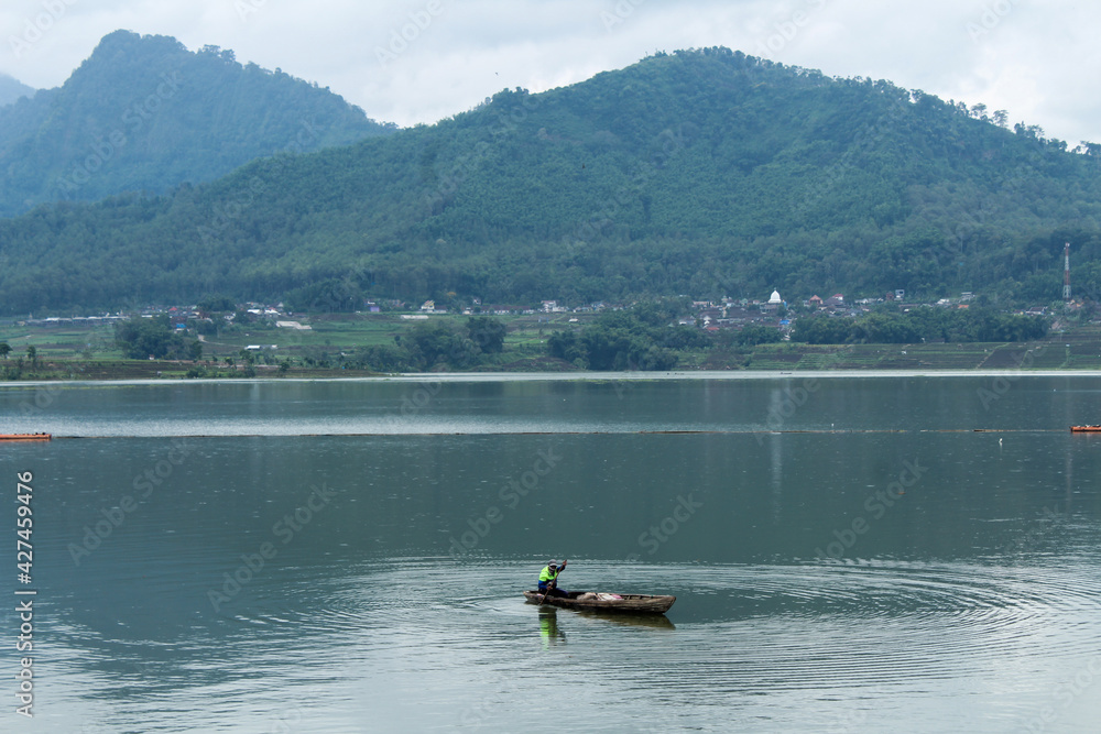 Fishermen sail in boats and mountainous backgrounds