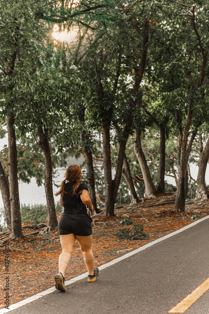 Asian oversize woman walking exercise in the park. Asian oversize woman walking exercise in the park.