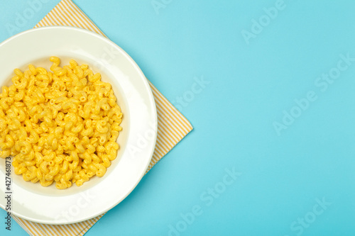 Pasta background. Mac and Cheese pasta on a blue background. American style Italian pasta with cheese.