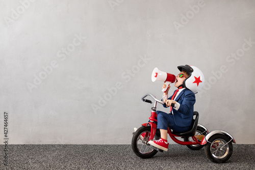 Foto Happy child wearing suit riding vintage bicycle