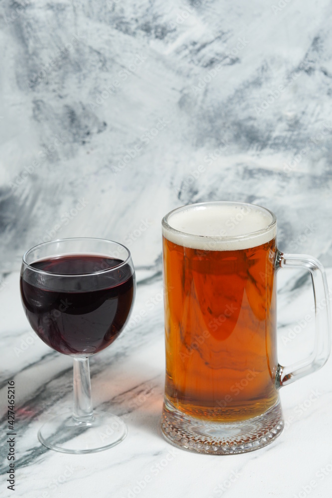 On a light background is a mug of beer, and a glass of red wine. Alcoholic beverages. Wine or beer to choose from. Bar card. On a light background is a mug of beer, and a glass of red wine. Alcoholic beverages. Wine or beer to choose from. Bar card.