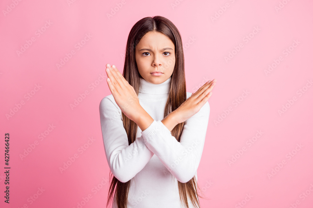 Photo of upset sad schoolgirl dressed white sweater arms crossed showing no stop gesture isolated pink color background Photo of upset sad schoolgirl dressed white sweater arms crossed showing no stop gesture isolated pink color background