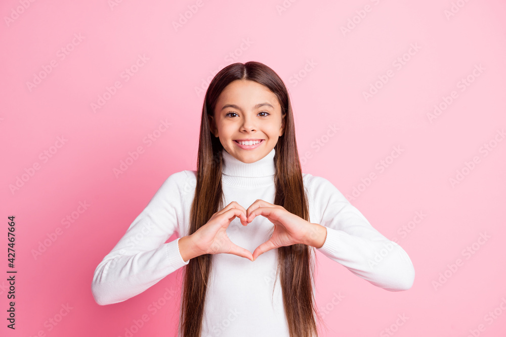 Photo of optimistic nice brunette girl show heart wear white sweater isolated on pastel pink color background Photo of optimistic nice brunette girl show heart wear white sweater isolated on pastel pink color background
