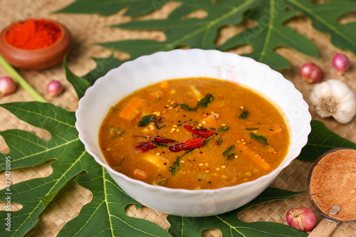 Sambar , Lentil sambar mixed vegetable curry soup for Onam sadhya vishu spicy hot isolated on green banana leaf. popular south Indian food in Kerala Tamil Nadu Sri lanka photo