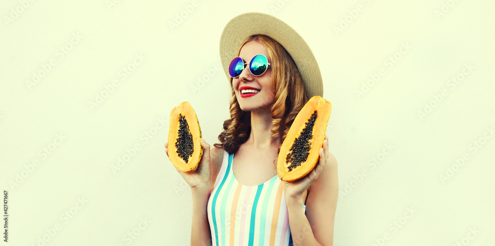 Summer portrait of happy smiling young woman with papaya wearing a straw hat, sunglasses on a white background Summer portrait of happy smiling young woman with papaya wearing a straw hat, sunglasses on a white background