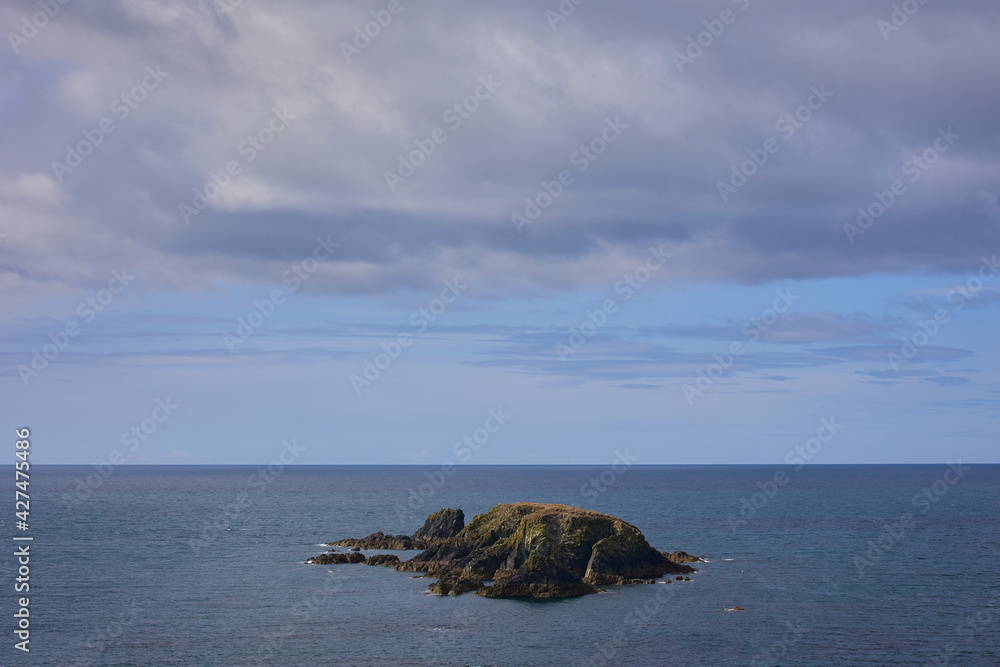 island-shaped rock formations surrounded by atlantic water . Kilfarrasy Beach. Co.Waterford Coastline, Ireland