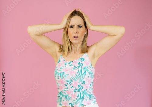 Excited young woman in casual clothes isolated over pink background