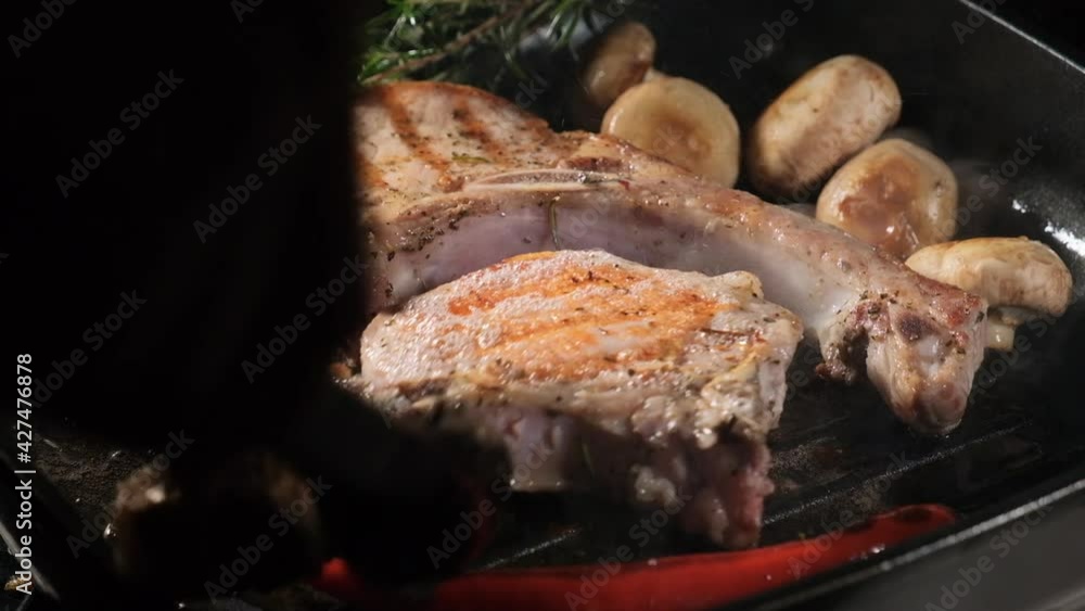 Grilling and turning meat and vegetables. Pork steak on the bone. HD, 50fps Grilling and turning meat and vegetables. Pork steak on the bone. HD, 50fps
