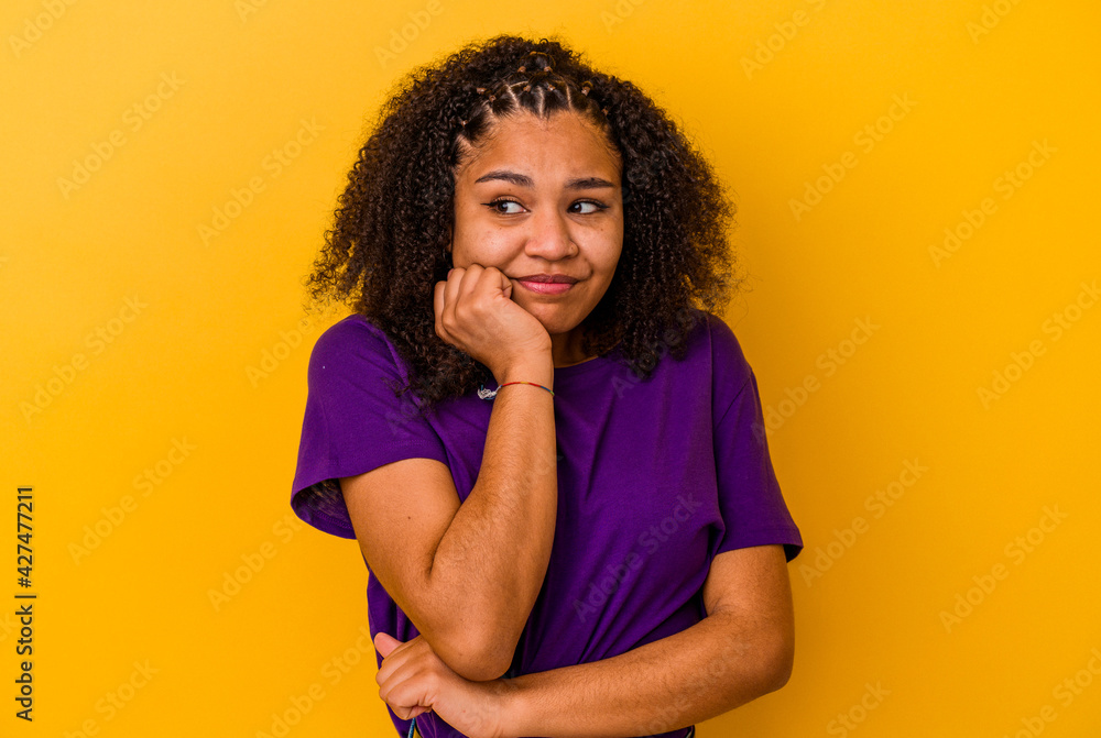 Young african american woman isolated on yellow background biting fingernails, nervous and very anxious. Young african american woman isolated on yellow background biting fingernails, nervous and very anxious.