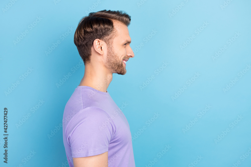 Side profile photo portrait of smiling guy wearing stylish outfit isolated on pastel blue color background Side profile photo portrait of smiling guy wearing stylish outfit isolated on pastel blue color background
