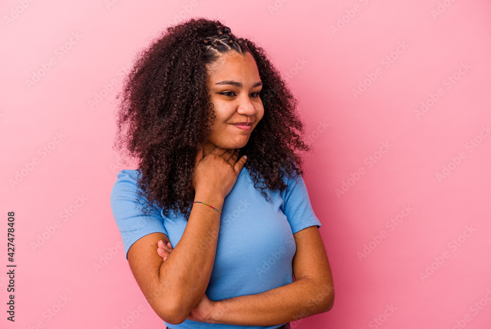 Young african american woman isolated on pink background suffers pain in throat due a virus or infection. Young african american woman isolated on pink background suffers pain in throat due a virus or infection.