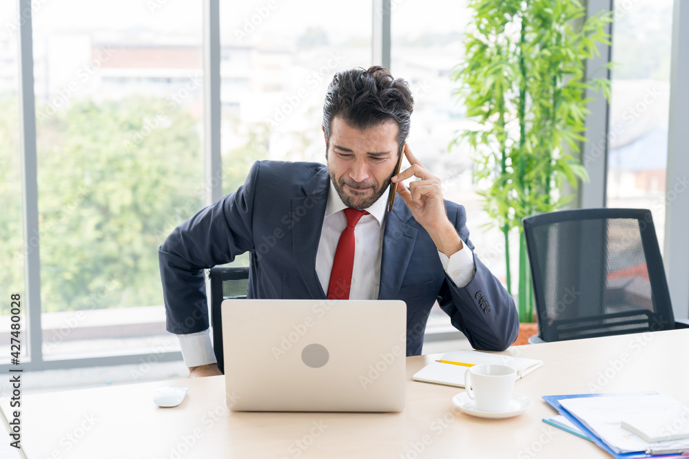 Stressed business man is thinking and analyze statistic and forecast sales revenue in his office Stressed business man is thinking and analyze statistic and forecast sales revenue in his office