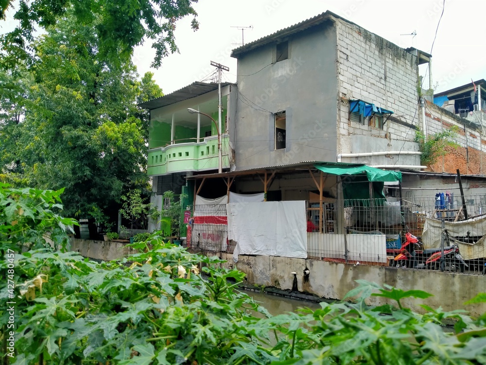Tambora, jakarta, Indonesia - (04-03-2021) : Slum house in front of a dirty river in a densely populated area Tambora, jakarta, Indonesia - (04-03-2021) : Slum house in front of a dirty river in a densely populated area