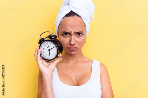 Young mixed race woman late for work isolated on yellow background