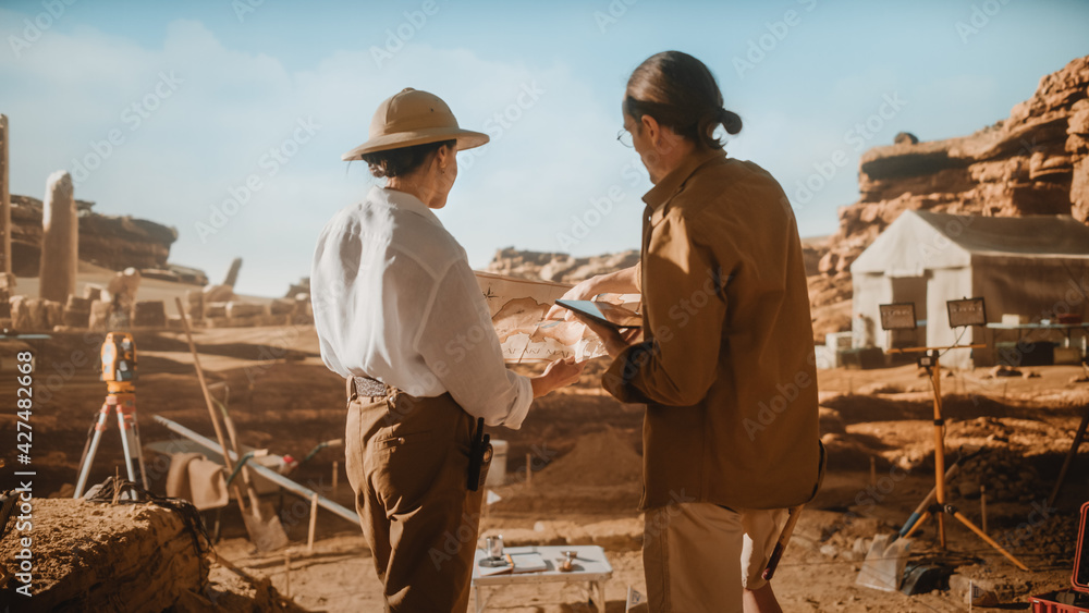 Archaeological Digging Site: Two Great Archeologists Work on Excavation Site, Use Map and Digital Tablet Computer to Inspect Newly Discovered Ancient Civilization Architectural Site, Planning Work Archaeological Digging Site: Two Great Archeologists Work on Excavation Site, Use Map and Digital Tablet Computer to Inspect Newly Discovered Ancient Civilization Architectural Site, Planning Work