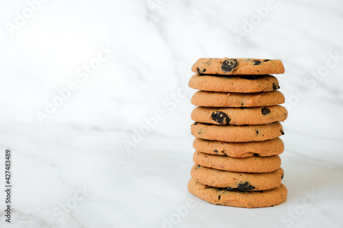 Stack of vegan cookies of oatmeal on marble background. Recipe of gluten free cookies with raisins, vegan diet snack. Copy space.