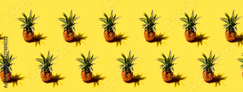Many pineapples on a solid yellow background pattern