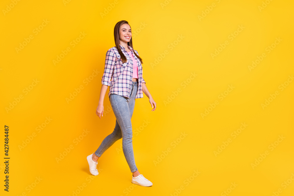 Full length body size view of attractive skinny cheerful girl going strolling isolated over bright yellow color background Full length body size view of attractive skinny cheerful girl going strolling isolated over bright yellow color background