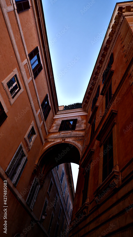 Street with arch in old town of Rome, Italy