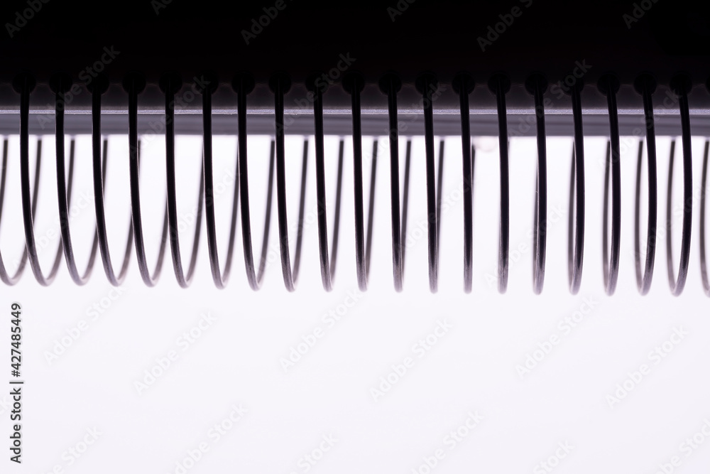 Notebook spiral spines silhouette macro shot Notebook spiral spines silhouette macro shot