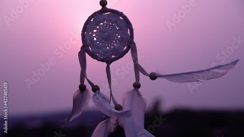 Dreamcatcher with white feather thread and beaded string. Handmade Dreamcatcher.The light of the setting sun.	