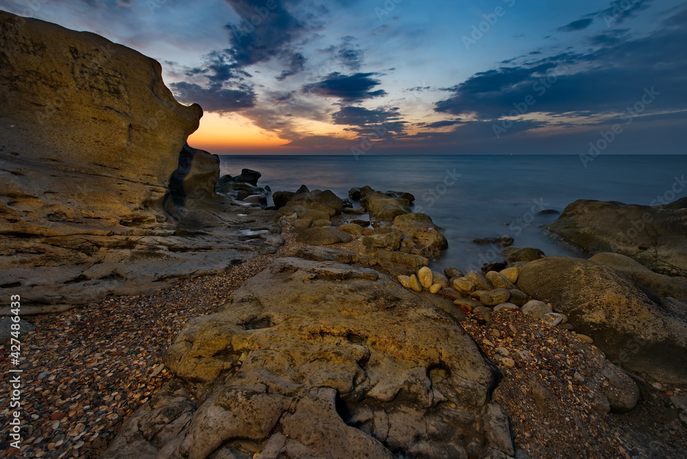 Russia. Dagestan. Dawn on the rocky shore of the Caspian Sea near the city embankment of Makhachkala.