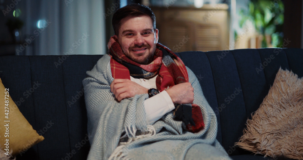 Home portrait of caucasian casual man catching cold covering with blanket warming-up posing into camera. Sickness, healthcare, pandemic. Social distance. Home portrait of caucasian casual man catching cold covering with blanket warming-up posing into camera. Sickness, healthcare, pandemic. Social distance.