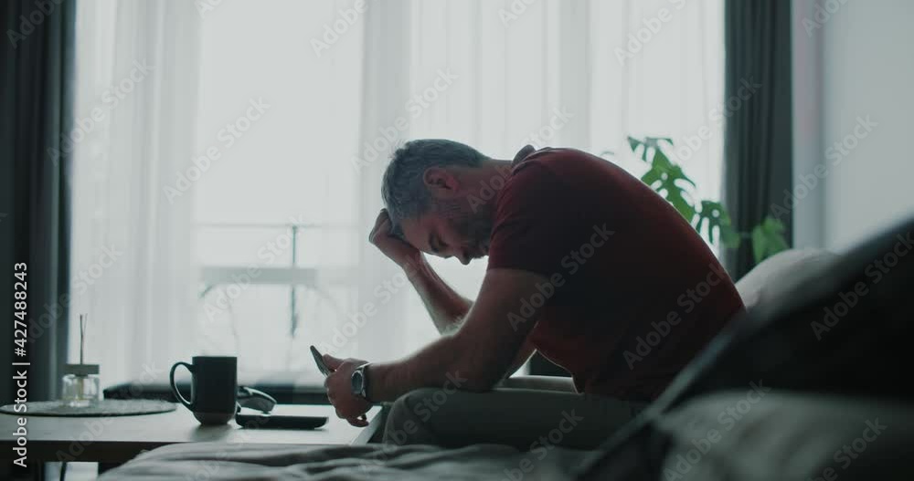 Sad man using mobile phone at home. Focused. Entrepreneur, technology, communication typing, business, lifestyle, touchscreen telephone. Slow motion Sad man using mobile phone at home. Focused. Entrepreneur, technology, communication typing, business, lifestyle, touchscreen telephone. Slow motion